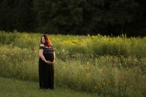 Pregnant mother standing in a wildflower field