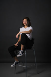 Teen model in studio sitting in high back chair